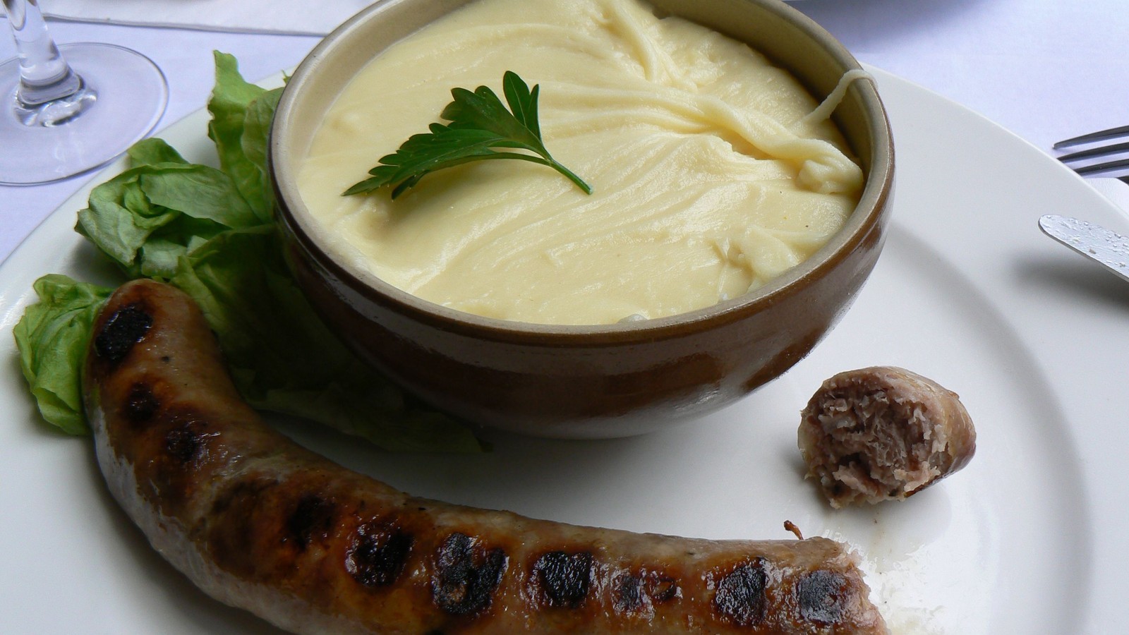 Aligot filé à la cuillère dans une grande marmite d'Aubrac